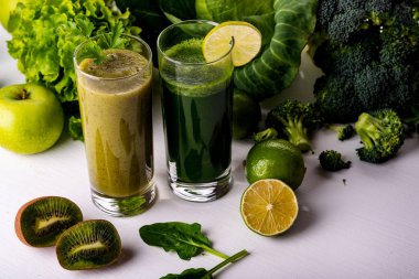Beyaz ahşap zemin üzerine yeşil smoothie kivi ve karnabahar içecekler. Çiğ yiyecek ve içecek.