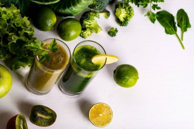 Beyaz ahşap zemin üzerine yeşil smoothie kivi ve karnabahar içecekler. Çiğ yiyecek ve içecek. Düz yatıyordu.