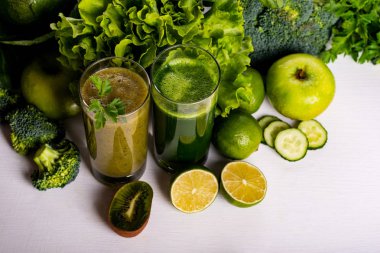 Beyaz ahşap zemin üzerine yeşil smoothie kivi ve karnabahar içecekler. Çiğ yiyecek ve içecek.