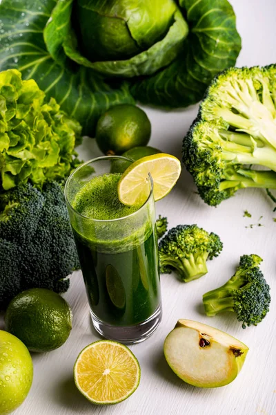 Zelené smoothie s jablky a citronem na bílém pozadí dřevěná. Syrové potraviny a nápoje. — Stock fotografie