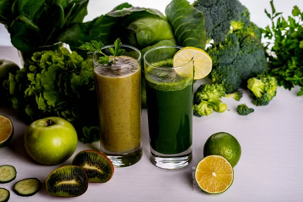 Kiwi de smoothie verde e bebidas de couve-flor em fundo de madeira branca. Alimentos e bebidas crus . — Fotografia de Stock