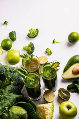 Beyaz ahşap arka planda farklı Sağlıklı Vegan ıspanak, kivi ve salatalık içecekler. Çiğ içecekler ve gıdalar. Düz yatma.