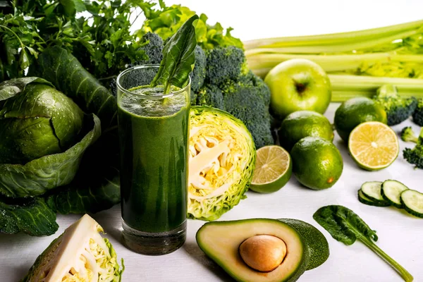 Green smoothie avocado and cauliflower drinks on white wooden background. Raw food and drink.