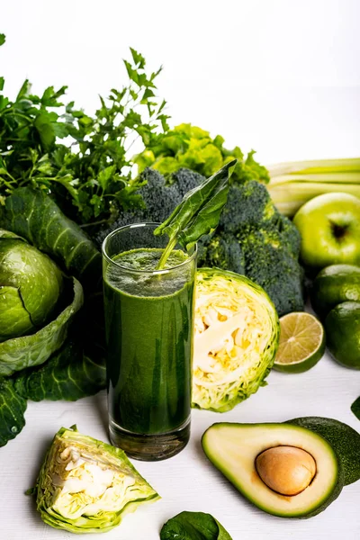 Smoothie drink met avocado, limoen en spinazie op witte houten achtergrond. Rauw eten en drinken. — Stockfoto