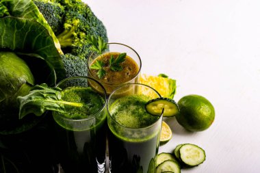 Beyaz ahşap arka planda ıspanak, kivi ve salatalık ile Vegan yiyecek ve içecekler. Çiğ içecekler ve gıdalar. Makro