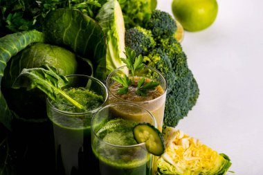 Beyaz ahşap arka planda ıspanak, kivi ve salatalık ile Vegan yiyecek ve içecekler. Çiğ içecekler ve gıdalar.