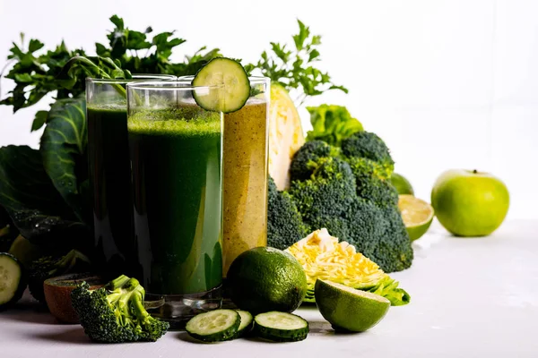 Comida e bebidas vegan com espinafre, kiwi e pepino no fundo de madeira branca. Bebidas e alimentos em bruto . — Fotografia de Stock