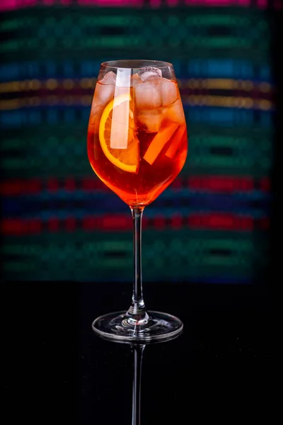 Aperol Spritz koktajl w szklance na czarnym stole odbicie we wnętrzu restauracji. — Zdjęcie stockowe