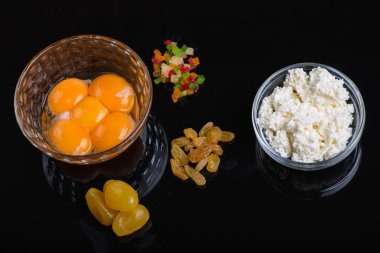 Siyah arka plan üzerinde cam bir kase parlak sarısı yumurta sarısı. Lezzetli yemekler pişirmek için malzemeler.