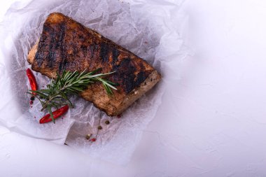 Beyaz arka planda otlar ile kavrulmuş domuz filetosu. Üstte görüntü.