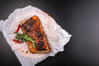 Siyah arka plan üzerinde baharat ile ızgara sığır biftek.