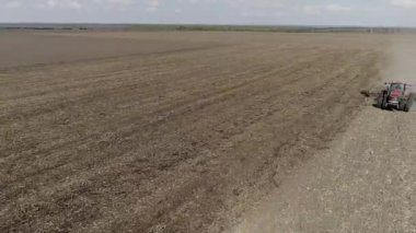 Çiftlikte çalışan traktör, modern tarımsal taşımacılık, tarlada çalışan bir çiftçi, verimli arazi, toprak ekimi, tarım makinesi