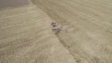 Traktördeki çiftçi tohum ekiciyle toprağı hazırlıyor.