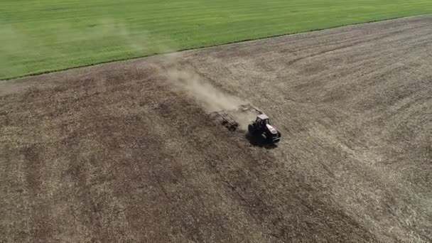 Agricultor en tractor preparando tierra con cultivador de semillero — Vídeos de Stock