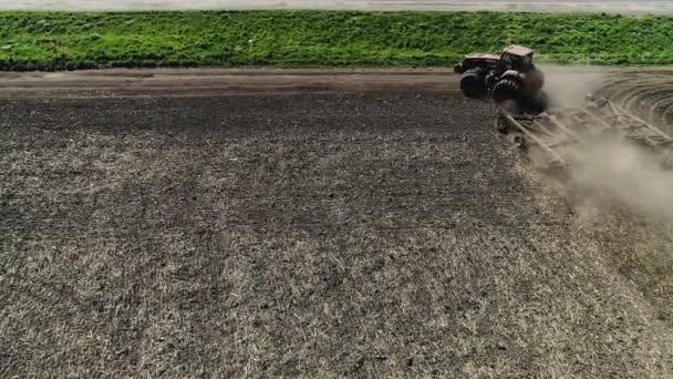 Agriculteur en tracteur préparant des terres avec cultivateur de lit de semence