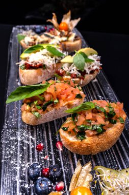 Peynir, bal, ceviz ve siyah arka plan üzerinde diğer malzemelerle meze bruschetta. Close. İtalyan yemekleri.
