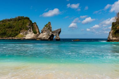 Tropikal plaj, deniz kayaları ve turkuaz okyanus, mavi gökyüzü görünümü. Atuh Beach, Nusa Penida, Endonezya.