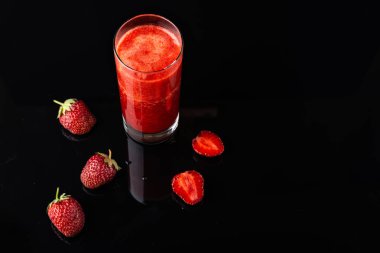 Siyah arka planda lezzetli çilek liyado. Taze çilek smoothie, yaz içeceği, olgun meyve vitamini ile sağlıklı antioksidan suyu.
