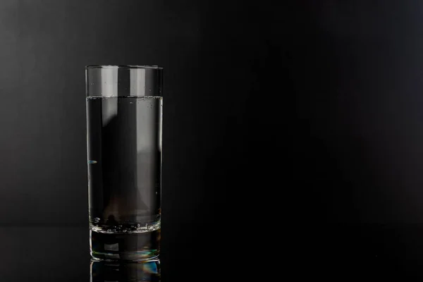 黑色背景的杯子水 — 图库照片