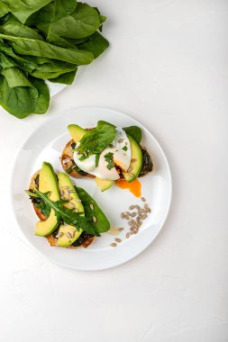 Kahvaltı. Ispanak, taze arugula ve tohumile haşlanmış yumurta ve avokado ile Ekmek tost