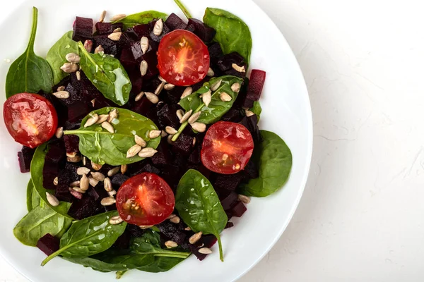 Healthy vegetarian food. Salad with beetroot, spinach, cherry tomatoes and seeds. — Stock Photo, Image