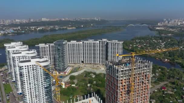 Luftaufnahme einer Landschaft in der Stadt mit im Bau befindlichen Gebäuden und Industriekränen. Baustelle. — Stockvideo