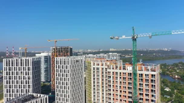 Vista aérea da paisagem na cidade com sob edifícios de construção e guindastes industriais. Local de construção . — Vídeo de Stock