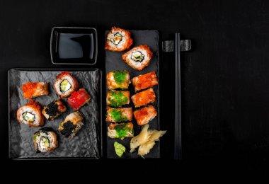 Taş masa üzerinde suşi rulo seti. Kopyalama alanı ile üstte görünüm.