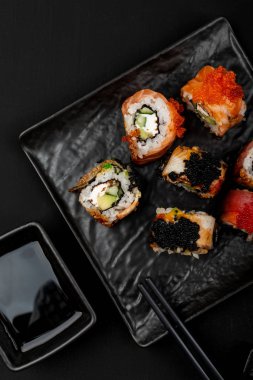 Taş masa üzerinde suşi rulo seti. Kopyalama alanı ile üstte görünüm.