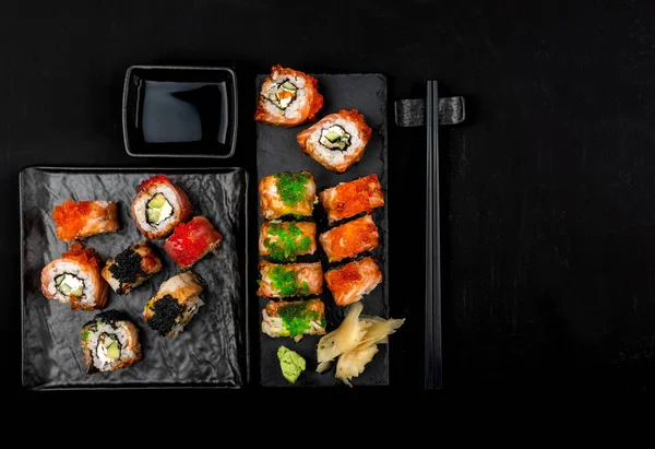 Taş masa üzerinde suşi rulo seti. Kopyalama alanı ile üstte görünüm.