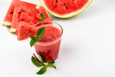 Karpuz smoothie nane ile taze meyve suyu, kalpler ve karpuz dilimleri şeklinde karpuz parçaları. Beyaz arka planda gözlüksağlıklı içecekler.