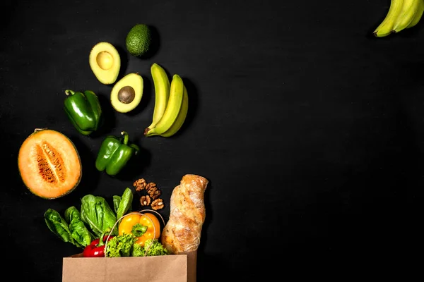 Satın alma konsepti. Sağlıklı gıda organik seçim. Siyah bir arka plan üzerinde farklı taze sebze dolu alışveriş kağıt torba. Üst görünüm, kopyalama alanı