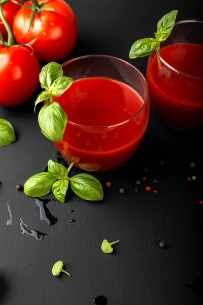 Tomatensaft mit Basilikum und Kirschtomaten auf schwarzem Hintergrund — Stockfoto