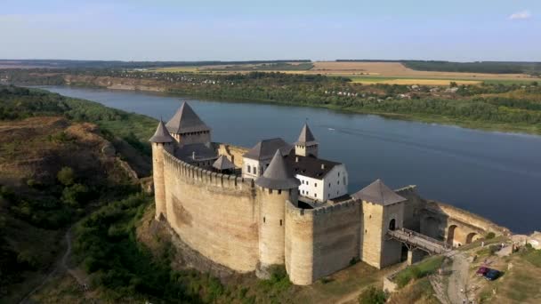 Vista aérea do castelo medieval de Hotyn na colina verde acima do rio. Ampliar . — Vídeo de Stock