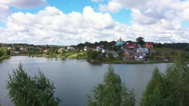Vue aérienne du magnifique paysage du village sur une colline près du lac. Mouvement de la caméra de bas en haut . — Video