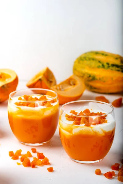Тыквенный десерт. Тыквенный коктейль с йогуртом и сушеными абрикосами в очках на белом фоне. Осень здоровой домашней диеты. Крупный план . — стоковое фото