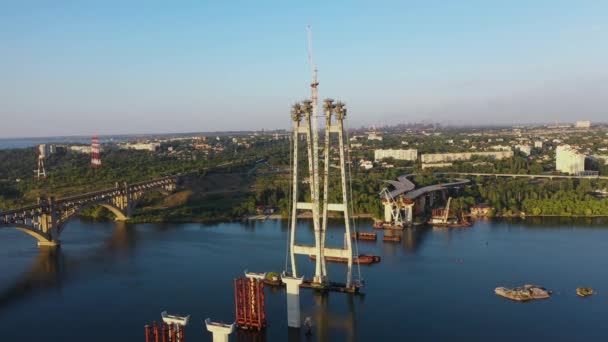 Unvollständige Automobilbrücke und Bogenbrücke im Hintergrund der Industriestadt. Kamerafahrt von rechts nach links. — Stockvideo