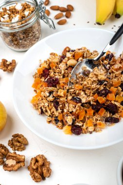 Sütlü müsli kahvaltı, kurutulmuş kayısı, kızılcık, badem ve keten tohumları beyaz arka planda. Sağlıklı kahvaltı..