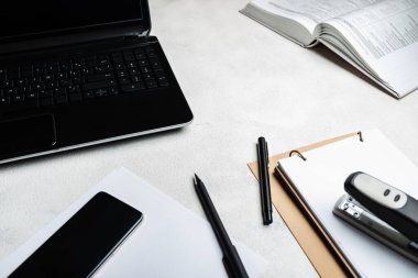 Bilgisayarlı ofis masası akıllı telefon defterleri kalemler yakın plan..