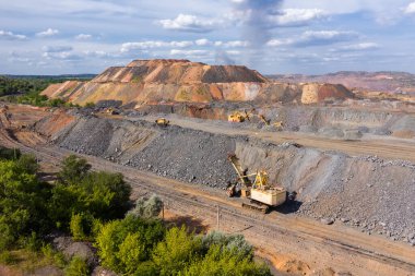 Kazıcı, bir maden tesisinde maden ekipmanlarının arka planına karşı duruyor. Madencilik endüstrisi.