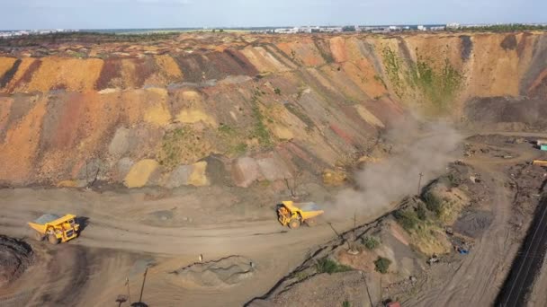 Twee grote mijnbouw dump truck gaat om elkaar te ontmoeten op een stoffige weg luchtfoto. — Stockvideo