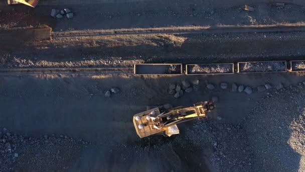 Excavatrice charge le minerai dans les wagons de marchandises vue aérienne du dessus. — Video