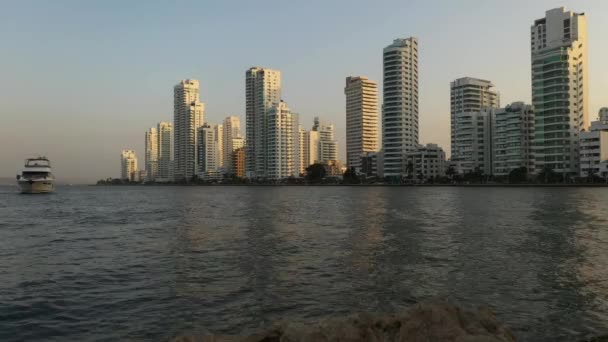 Cartagenaの日没時に高層ビルのビジネスアパートホテルに近い美しい近代的なヨットコロンビアの空の景色. — ストック動画