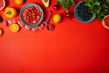 Sağlıklı yiyecek sınırı ve kırmızı arka planda şerit. Kilo verme konsepti. Kopyalama alanı olan üst görünüm.