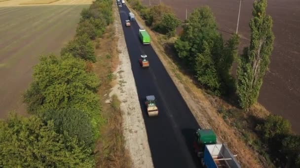 Rolos rodoviários construindo o novo asfalto estrada vista panorâmica aérea. — Vídeo de Stock