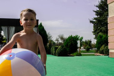 litlle çocuk topu havuzun tutuyor.