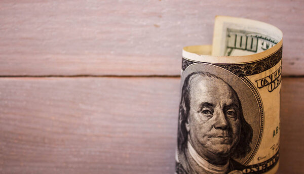 100 долларов на деревянном фоне
