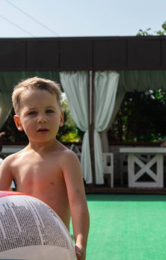 litlle çocuk topu havuzun tutuyor.