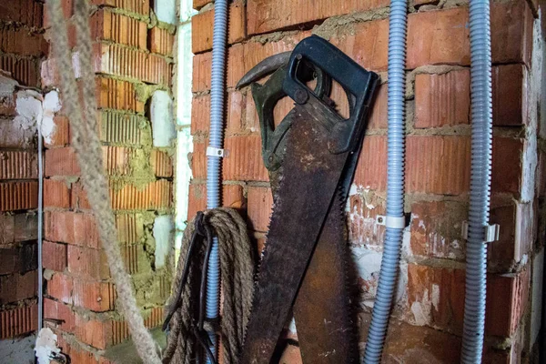 two saws on a brick wall