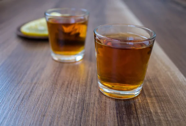 Dvě Hromádky Whisky Plátky Citronu Dřevěné Pozadí — Stock fotografie